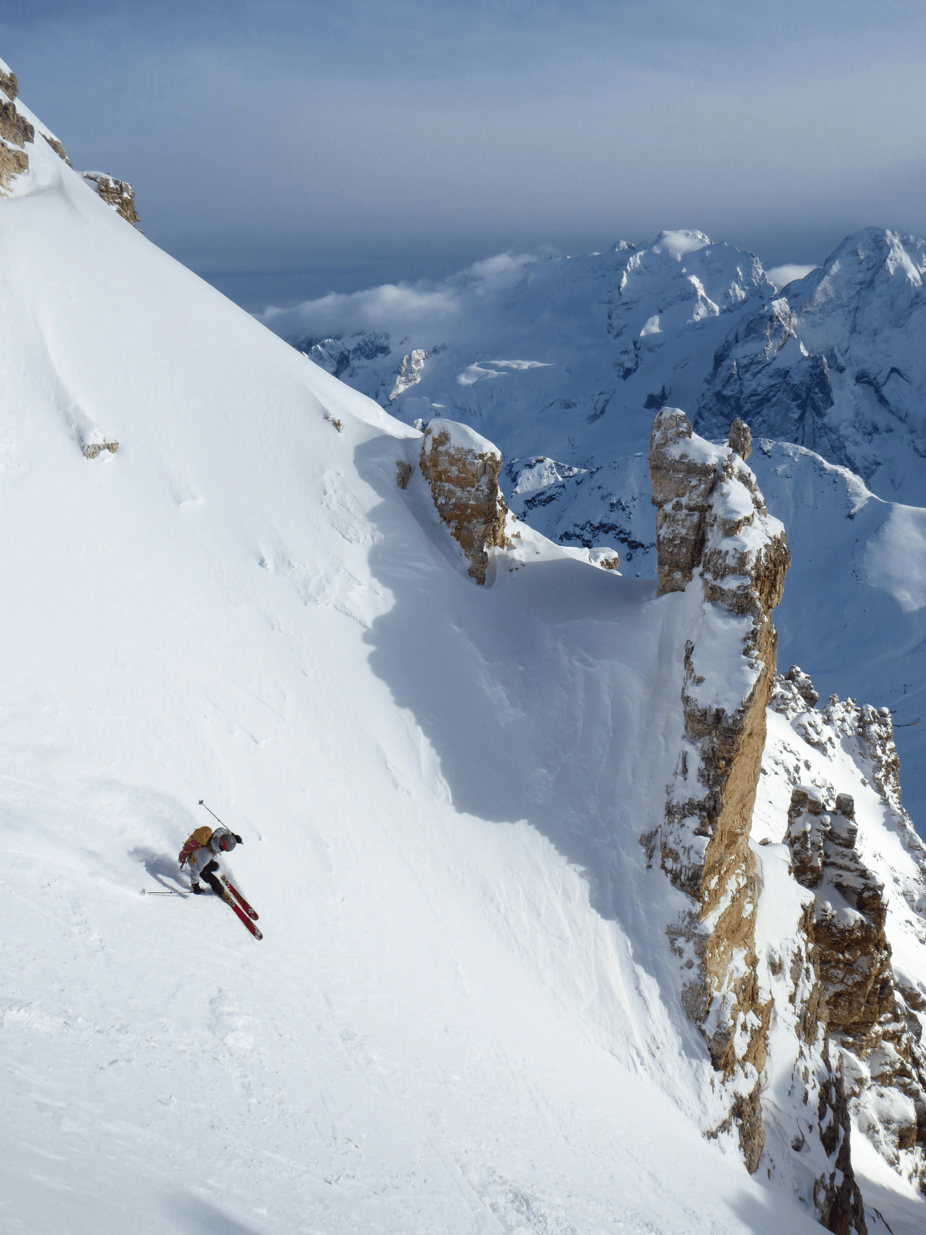 Skier gliding down a snow-covered mountain during a winter adventure sport, showcasing snow activities and outdoor adventure experiences.