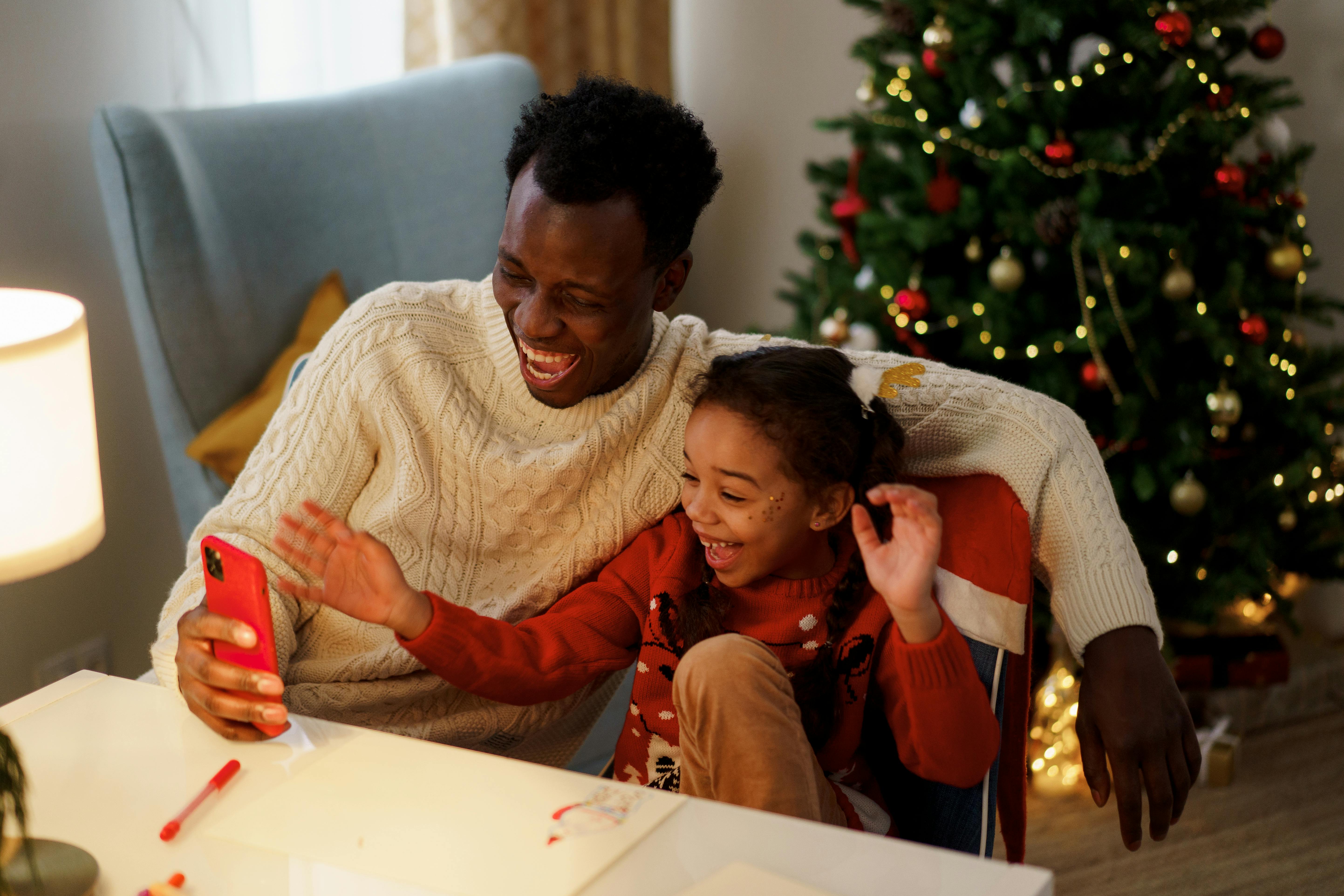 Father and daughter laughing at phone