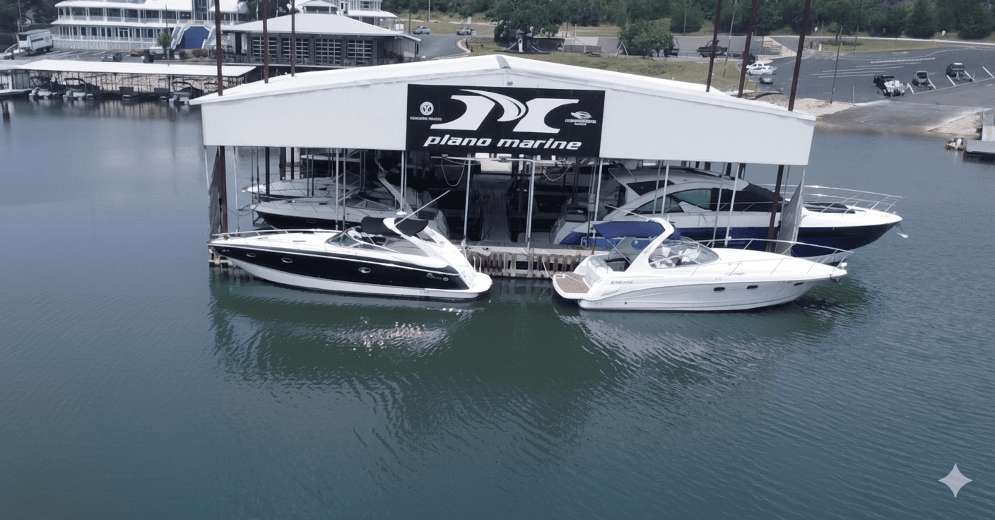 A marina display showcasing several sleek, white motorboats docked under a large, covered structure with signage above, surrounded by calm waters.