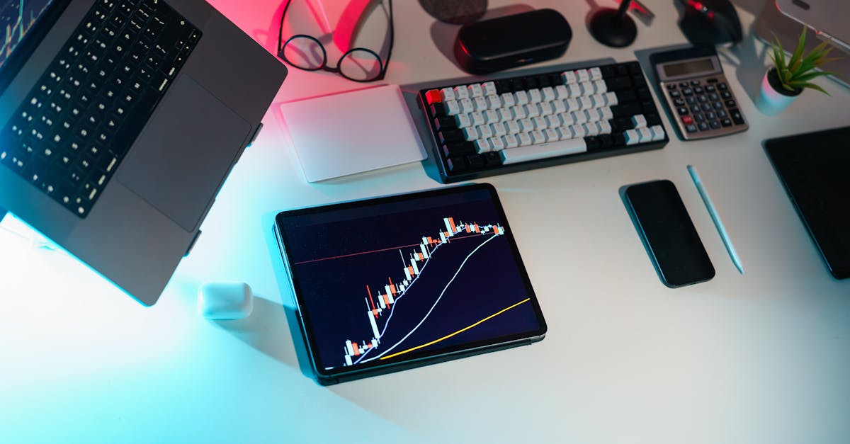 A modern desk setup featuring financial analytics on digital devices in an office setting.