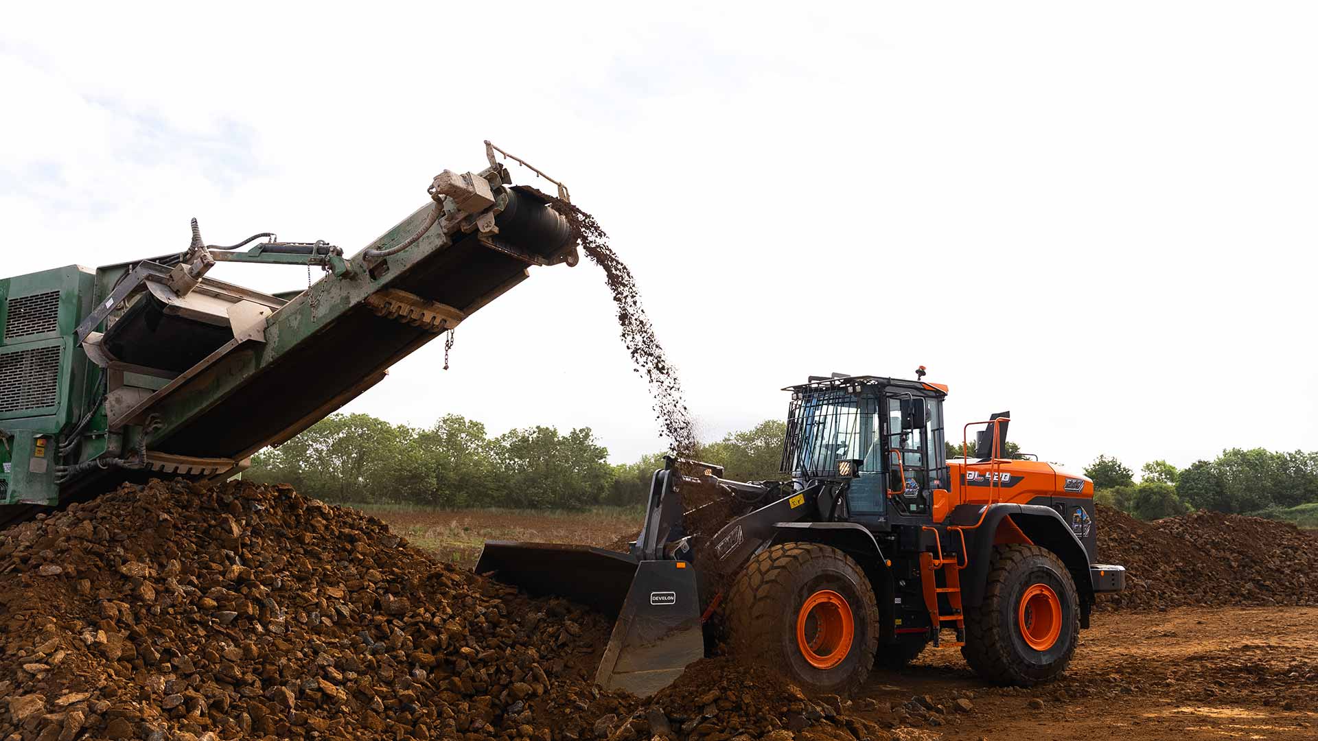 ETC front loader collecting screened aggregate from mobile crusher during waste handling operations