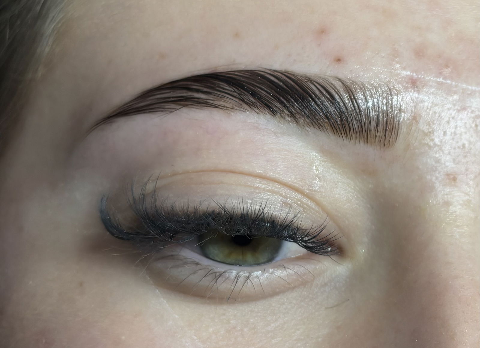 Combo browlift et extensions de cils sur œil vert – sourcils restructurés et cils volumineux pour un regard équilibré et raffiné.