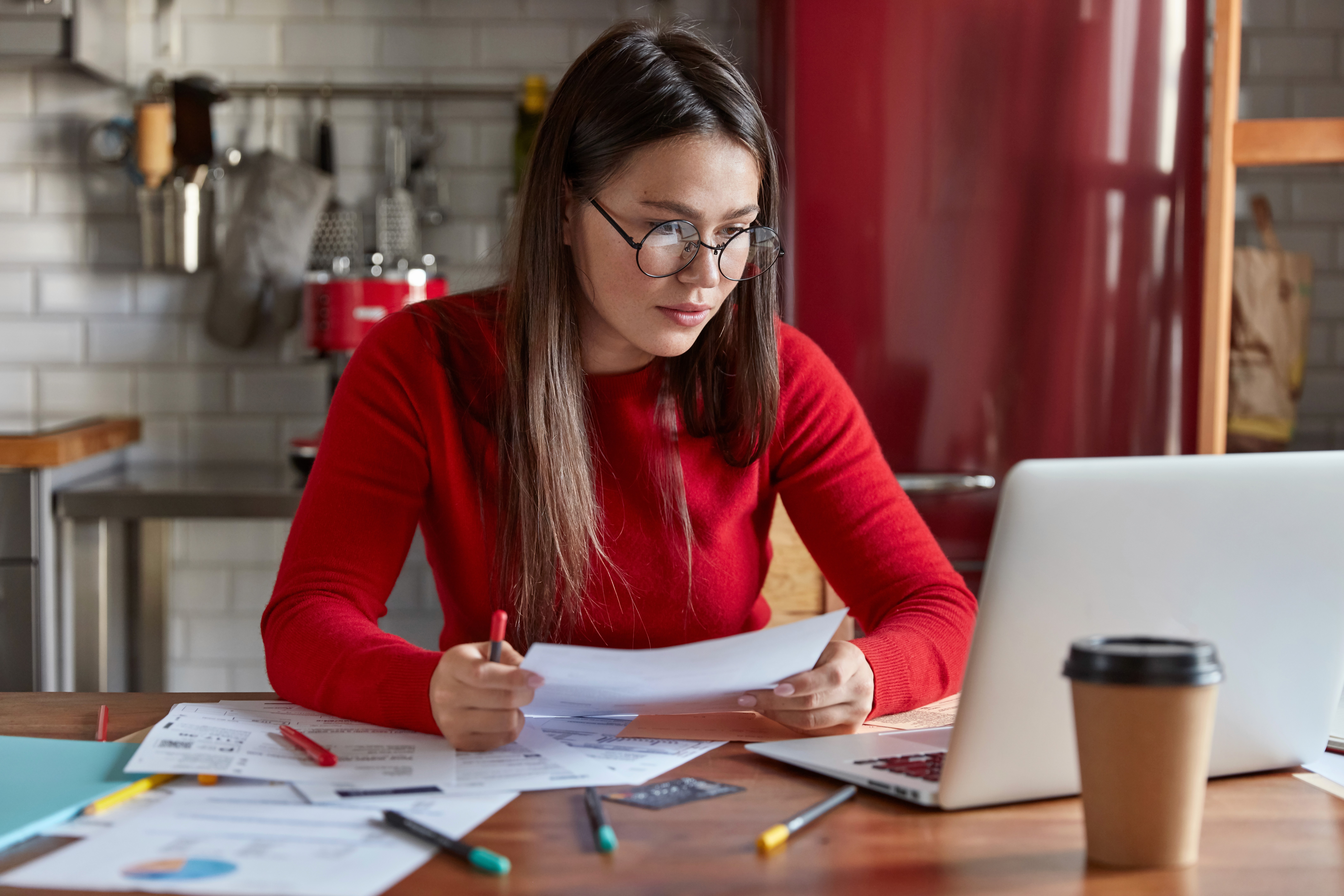 horizontal-shot-busy-freelance-worker-reads-information-data-papers