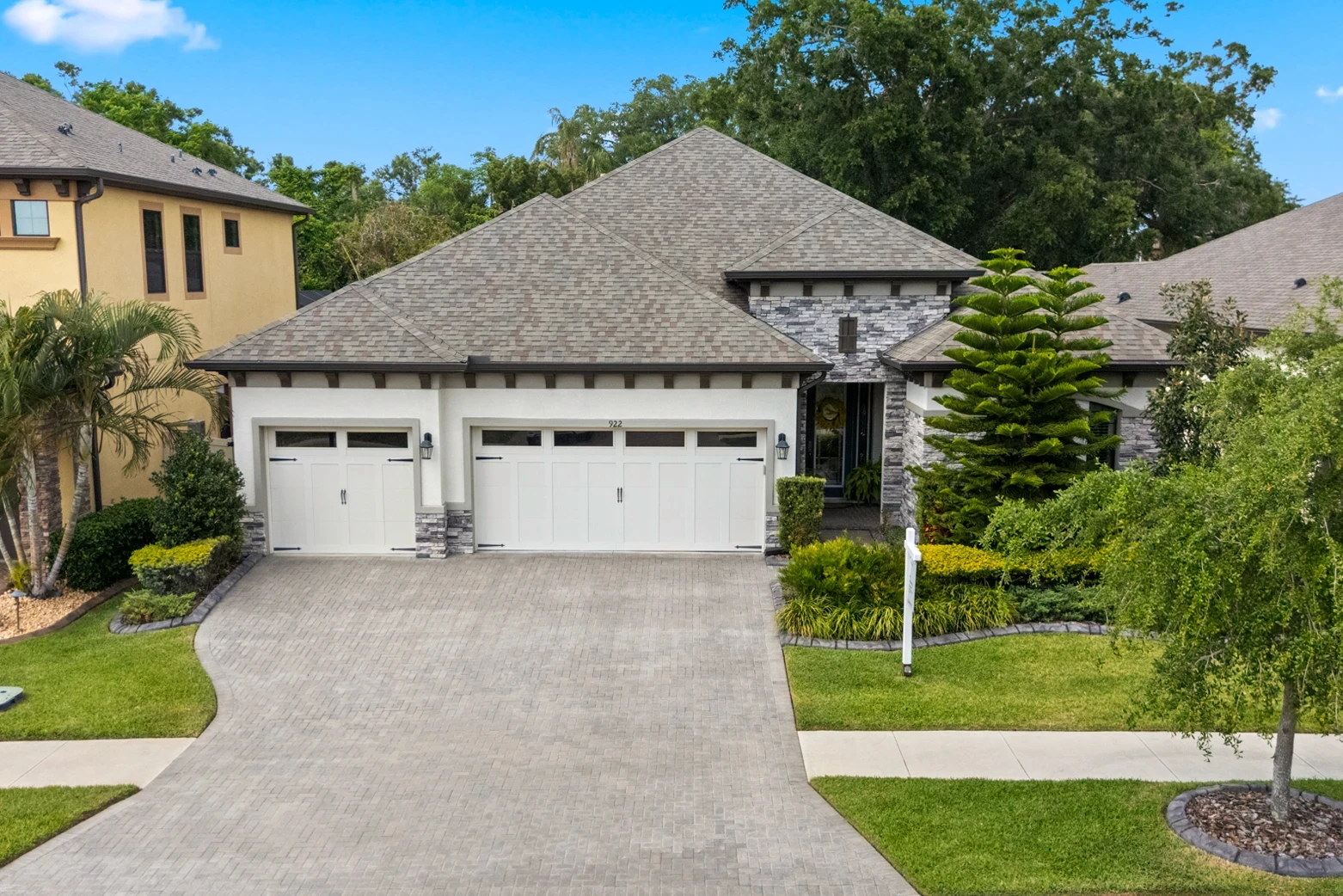 Two-story Brandon, FL home with stone accents, three-car garage and manicured landscaping