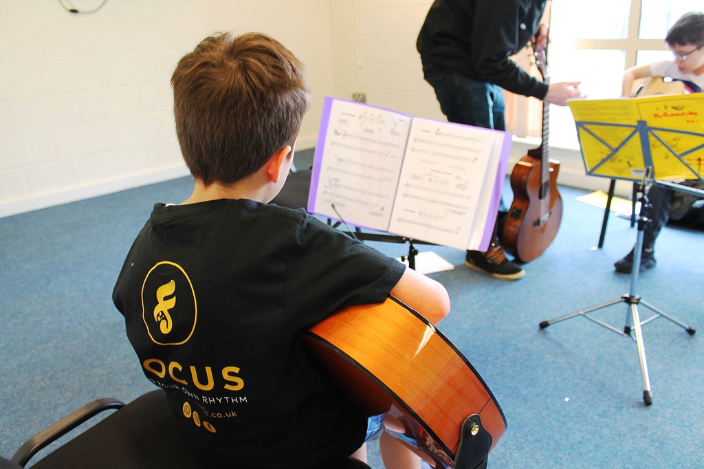 Student in the classroom practising the Guitar 