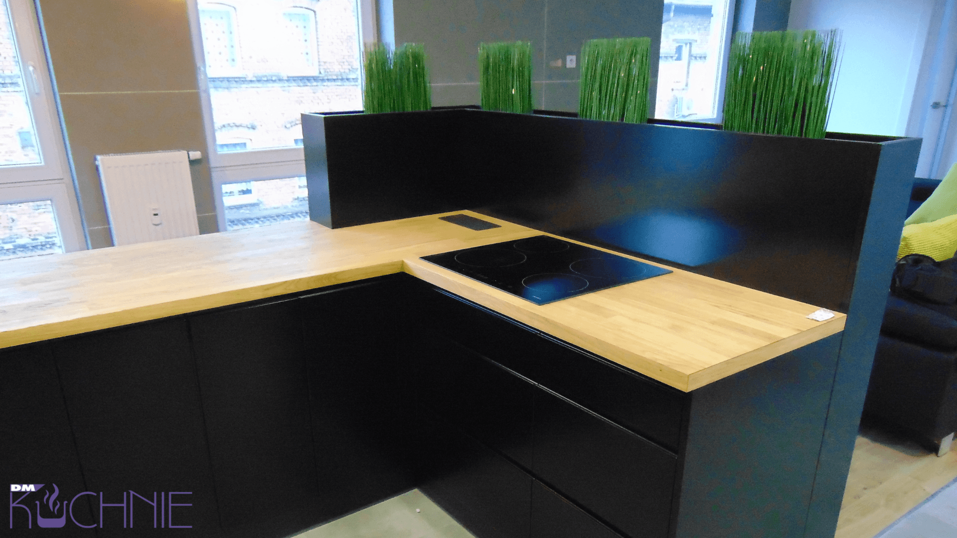 Meble kuchenne na wymiar w Warszawie – minimalistyczna zabudowa z drewnianym blatem i płytą indukcyjną