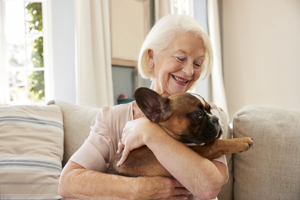 Happy senior woman and dog in her assisted living apartment