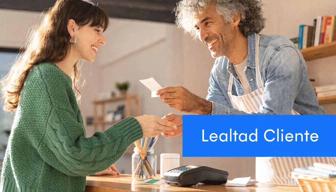 Un comerciante sonriente entrega un recibo a una clienta en el mostrador de una pequeña tienda.
