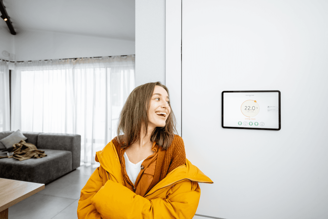 Eine Frau die sich über die Steigende Temperatur in ihrer Wohnung freut. Die Wärmepumpe mit innenaufstellung funktioniert