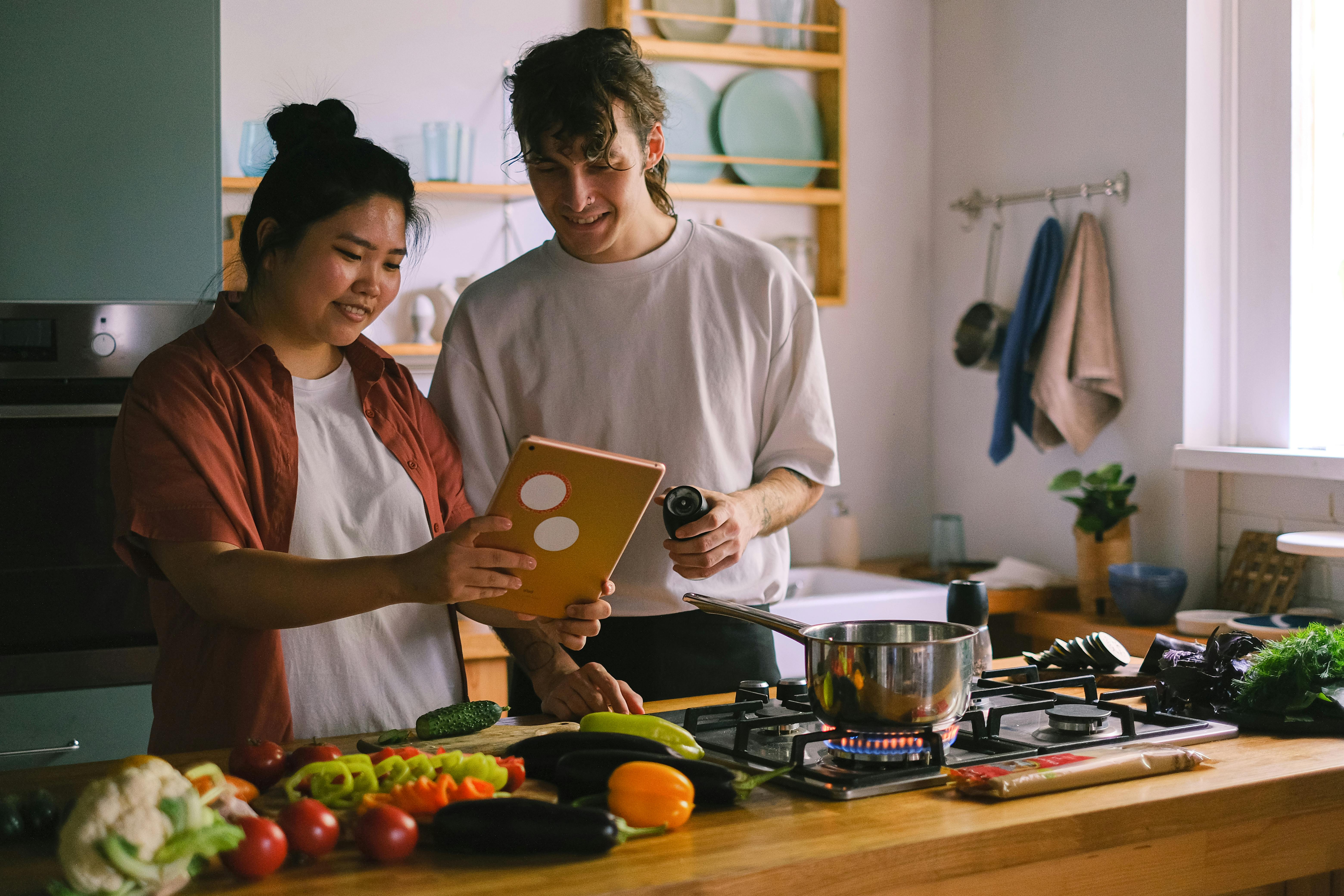 Mixed race couple readng a cookbook in the kitchen
