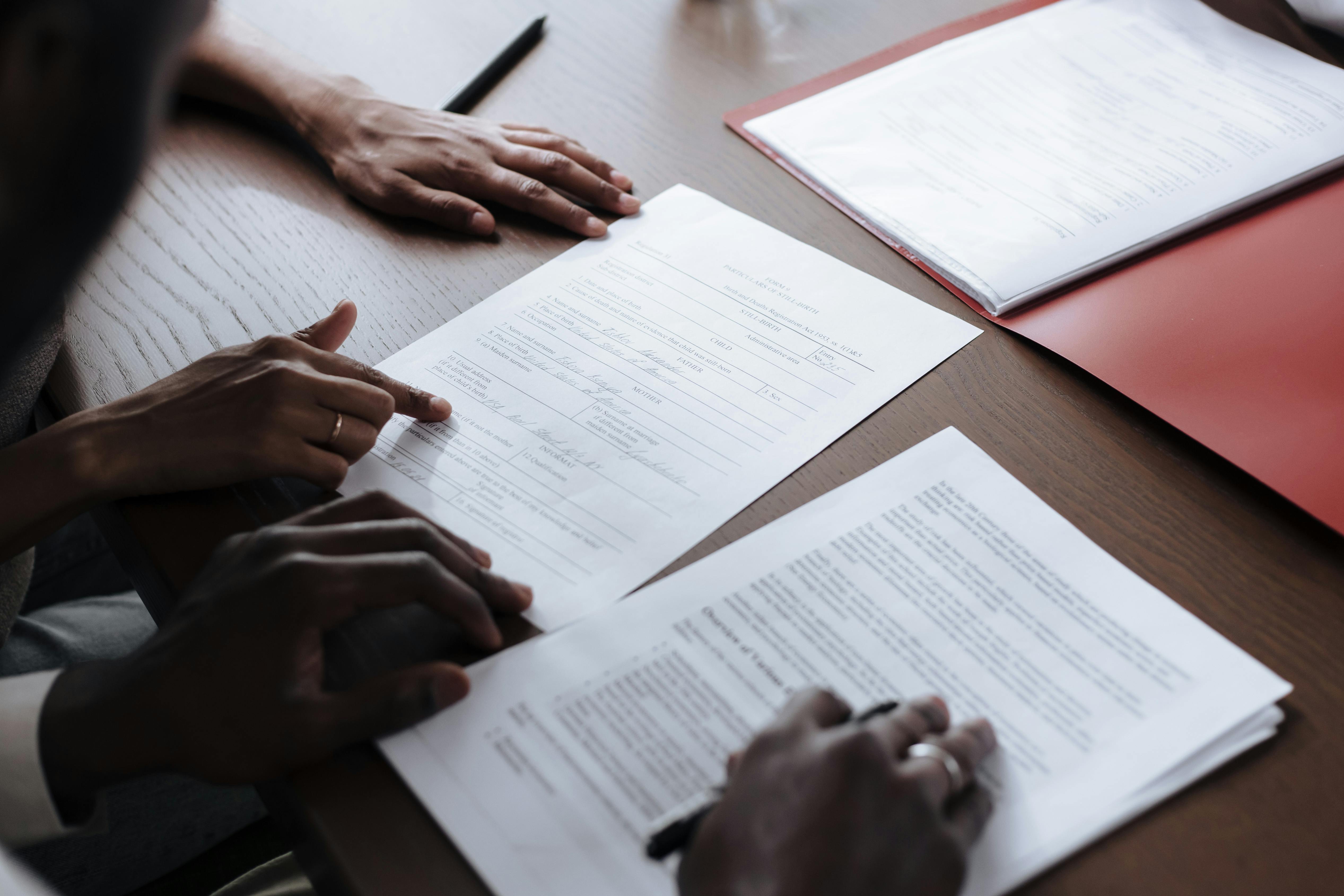 Two people reviewing documents at a table.