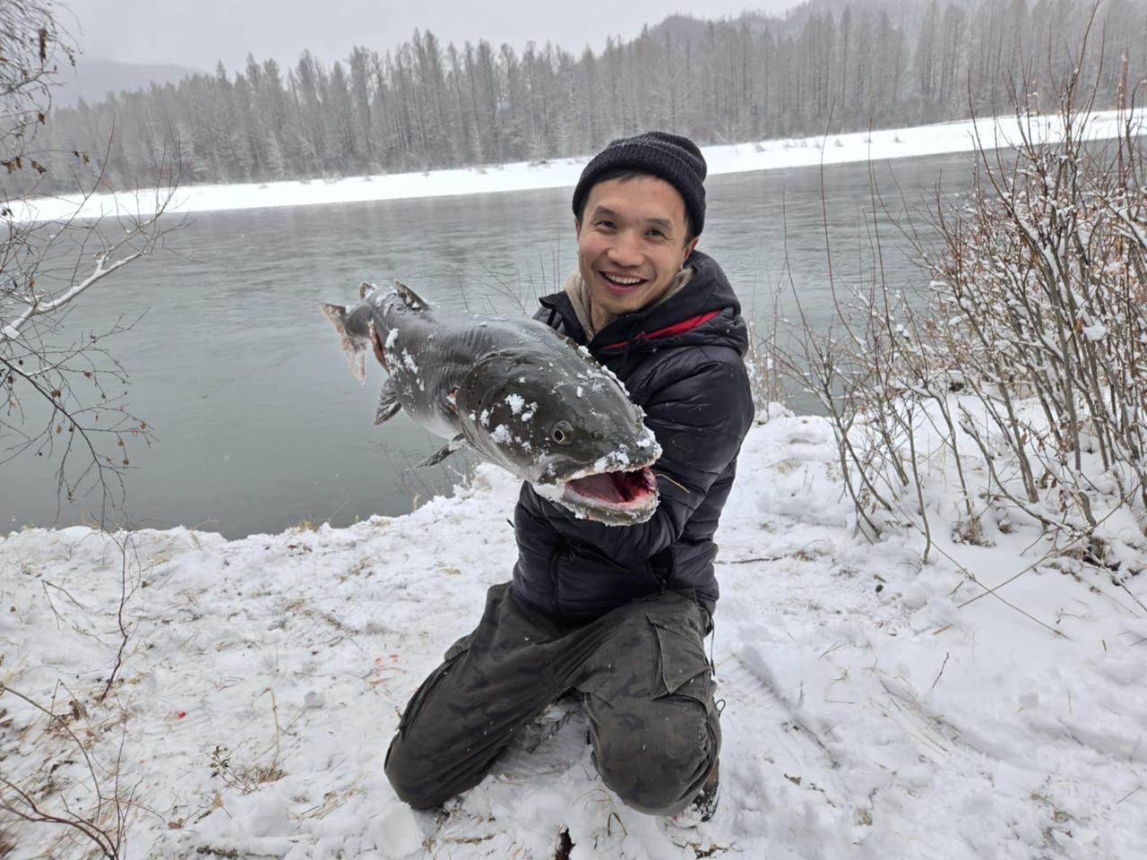Mongolian fisherman holding a big Taimen fish