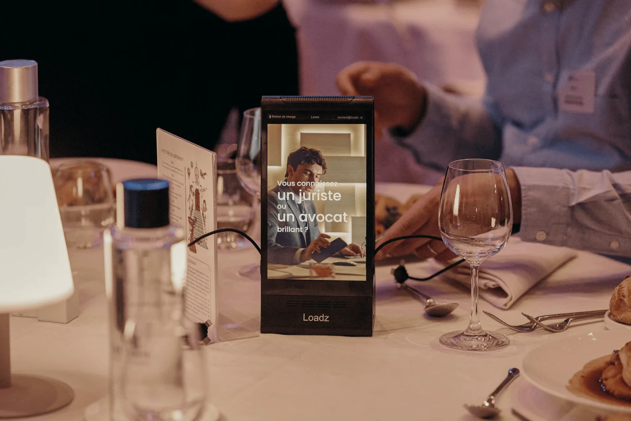 Black patent leather shoes and wide-leg pants stand on a deep red carpet, conveying a sense of elegance and sophistication.