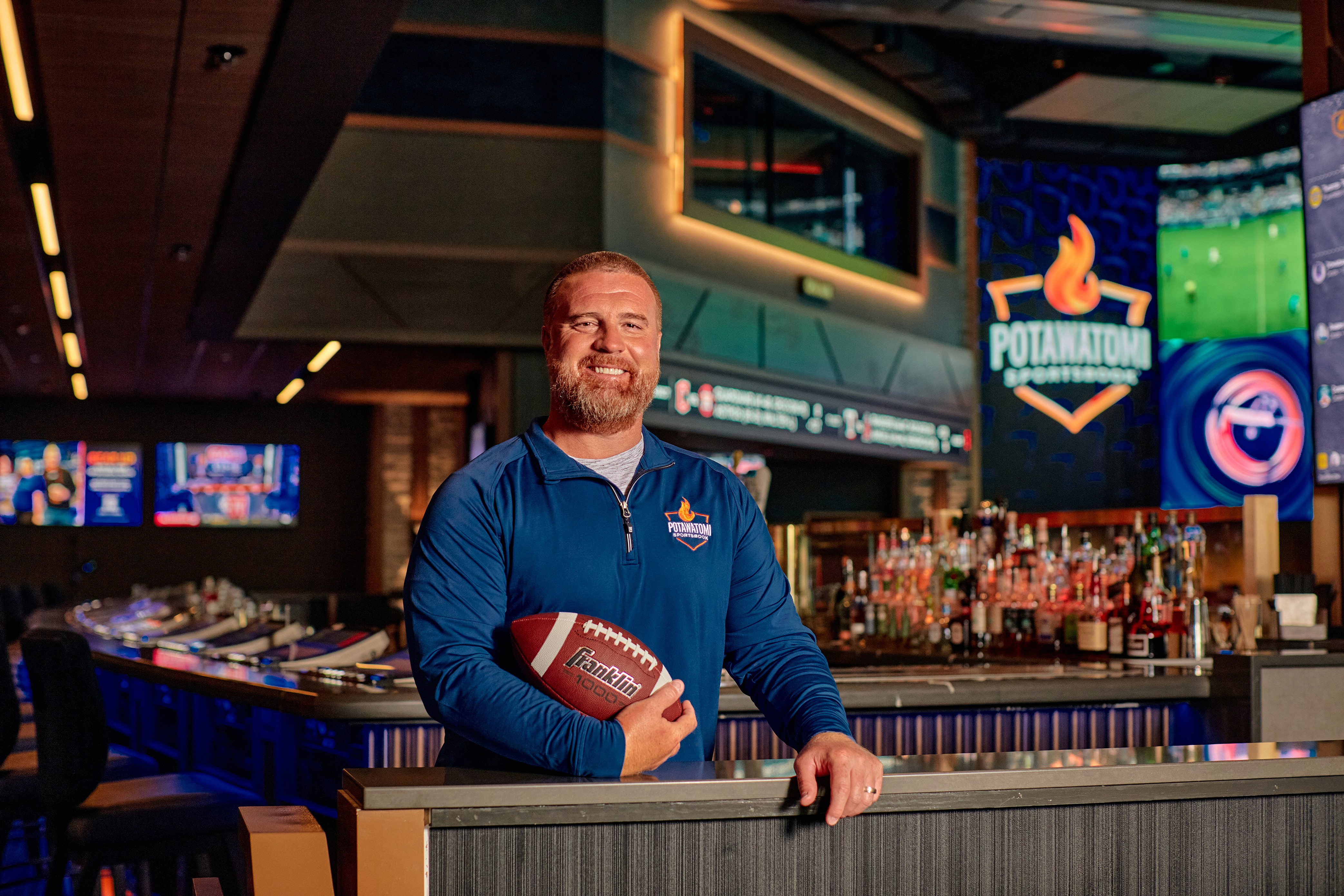 John Kuhn posing with football in the Sportsbook