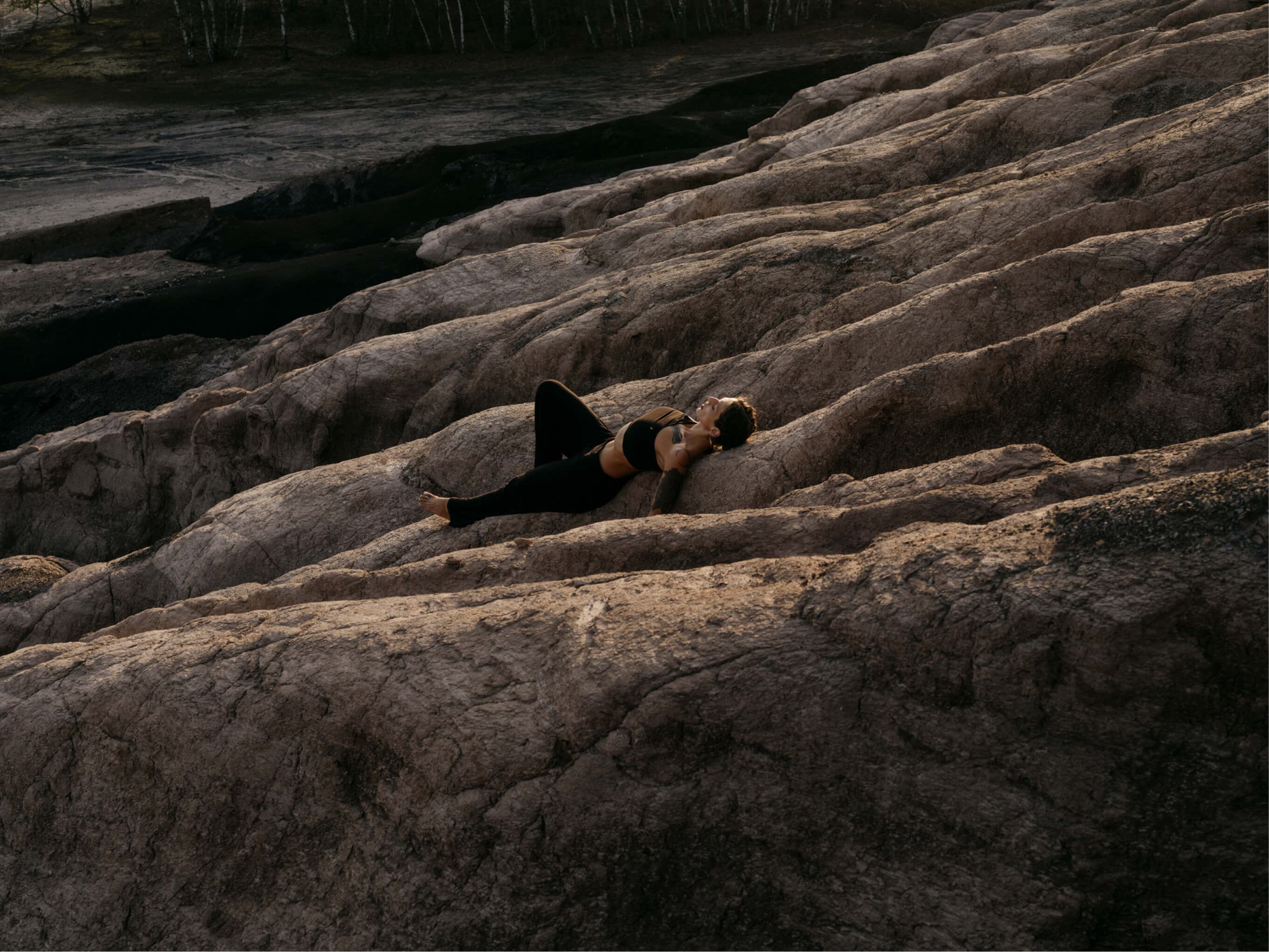 Blertë Dibrani liegend auf einem Felsen