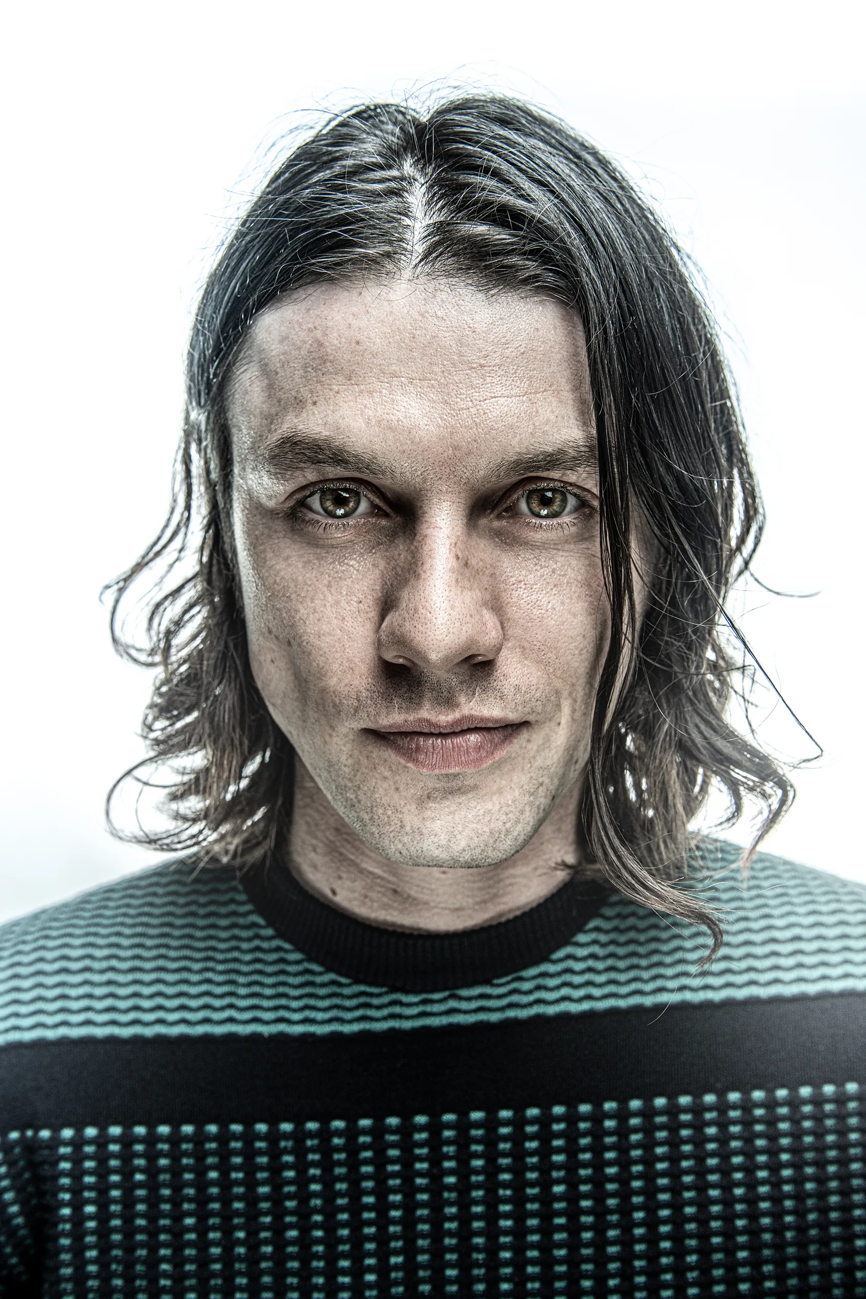 Portrait of James Bay looking at the camera with soft cinematic lighting.