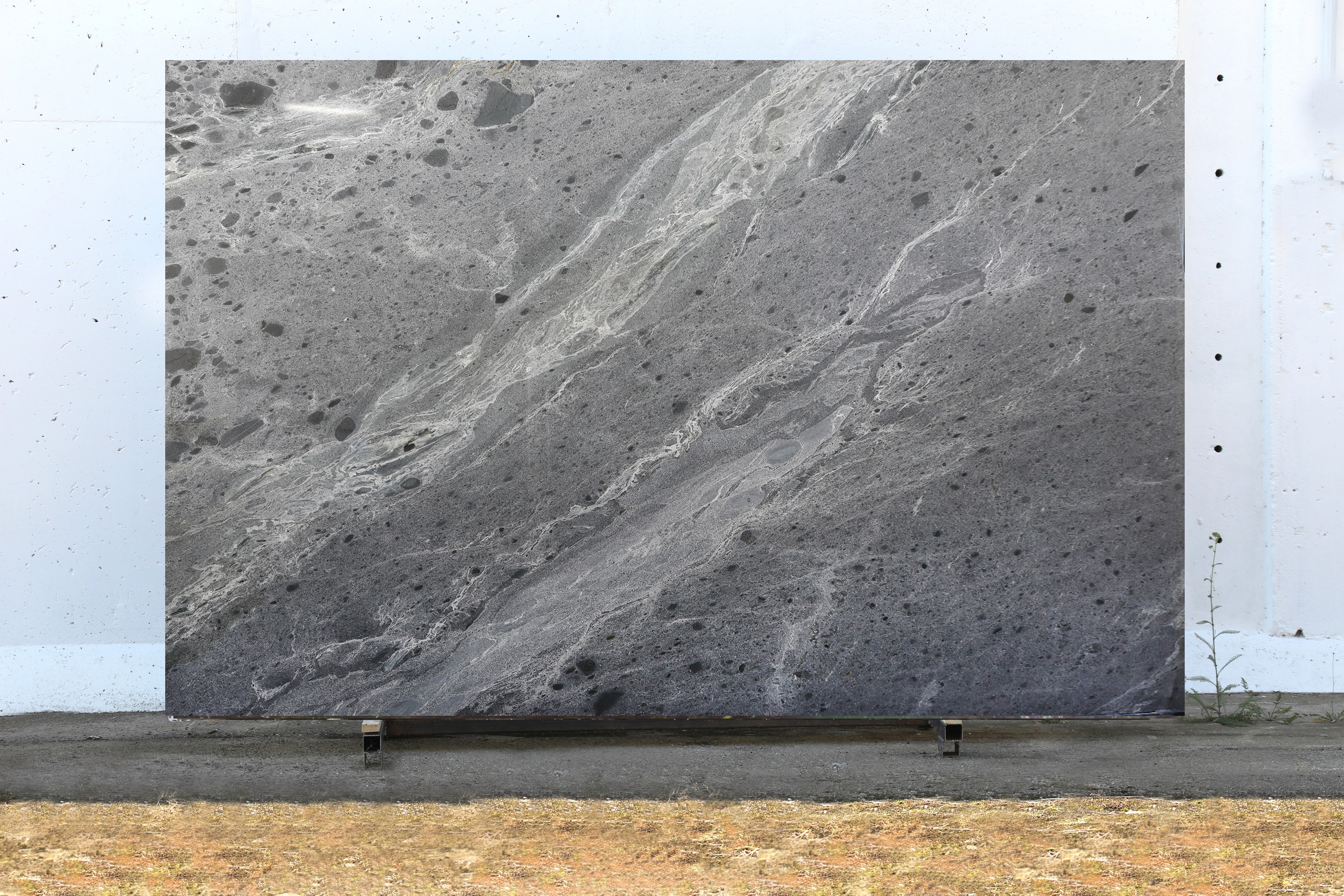 Graue Natursteinplatte mit feiner, heller Maserung.