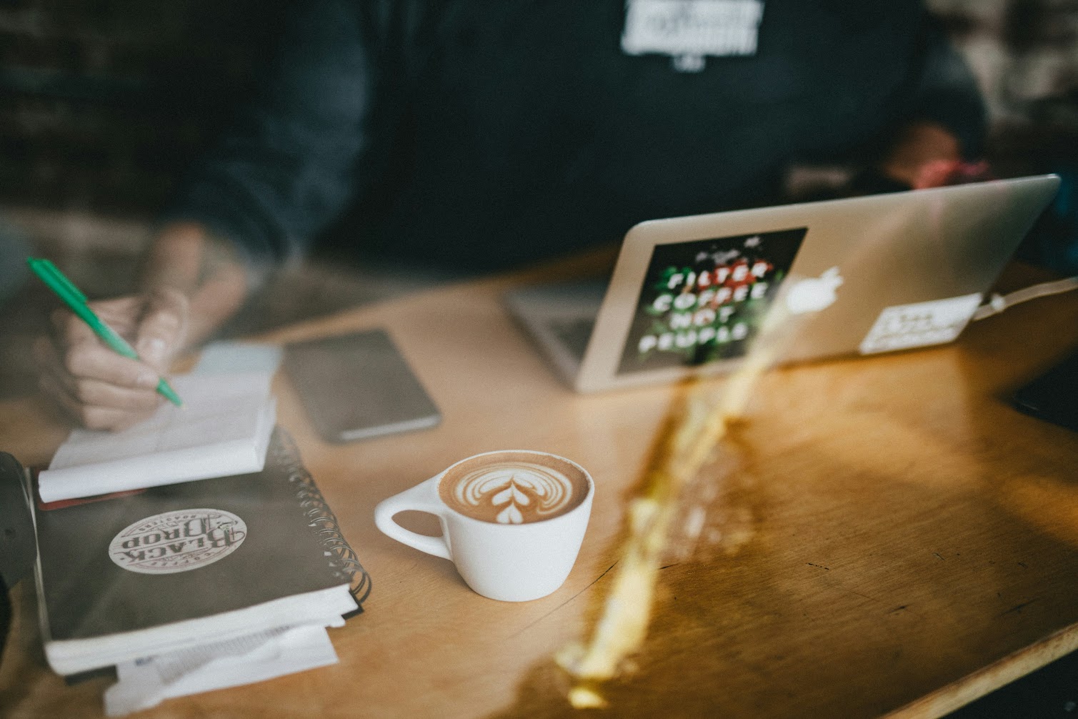 Person having a cup of coffee while working at a desk