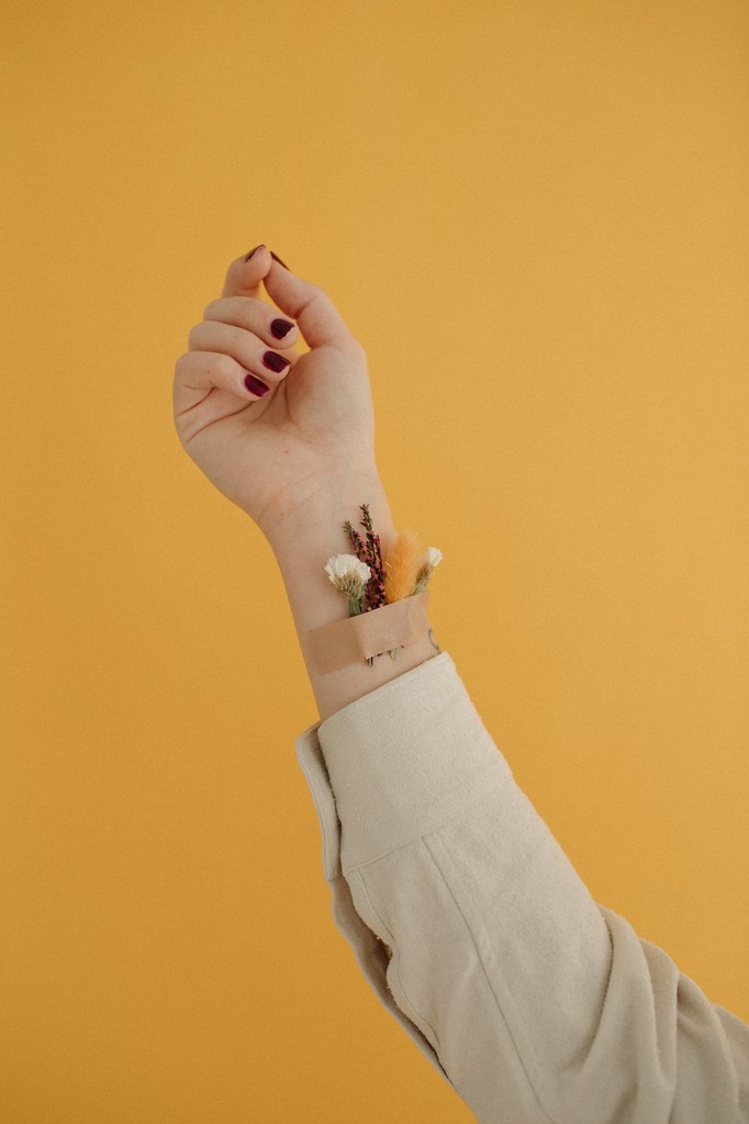 Flowers taped to arm with yellow backdrop