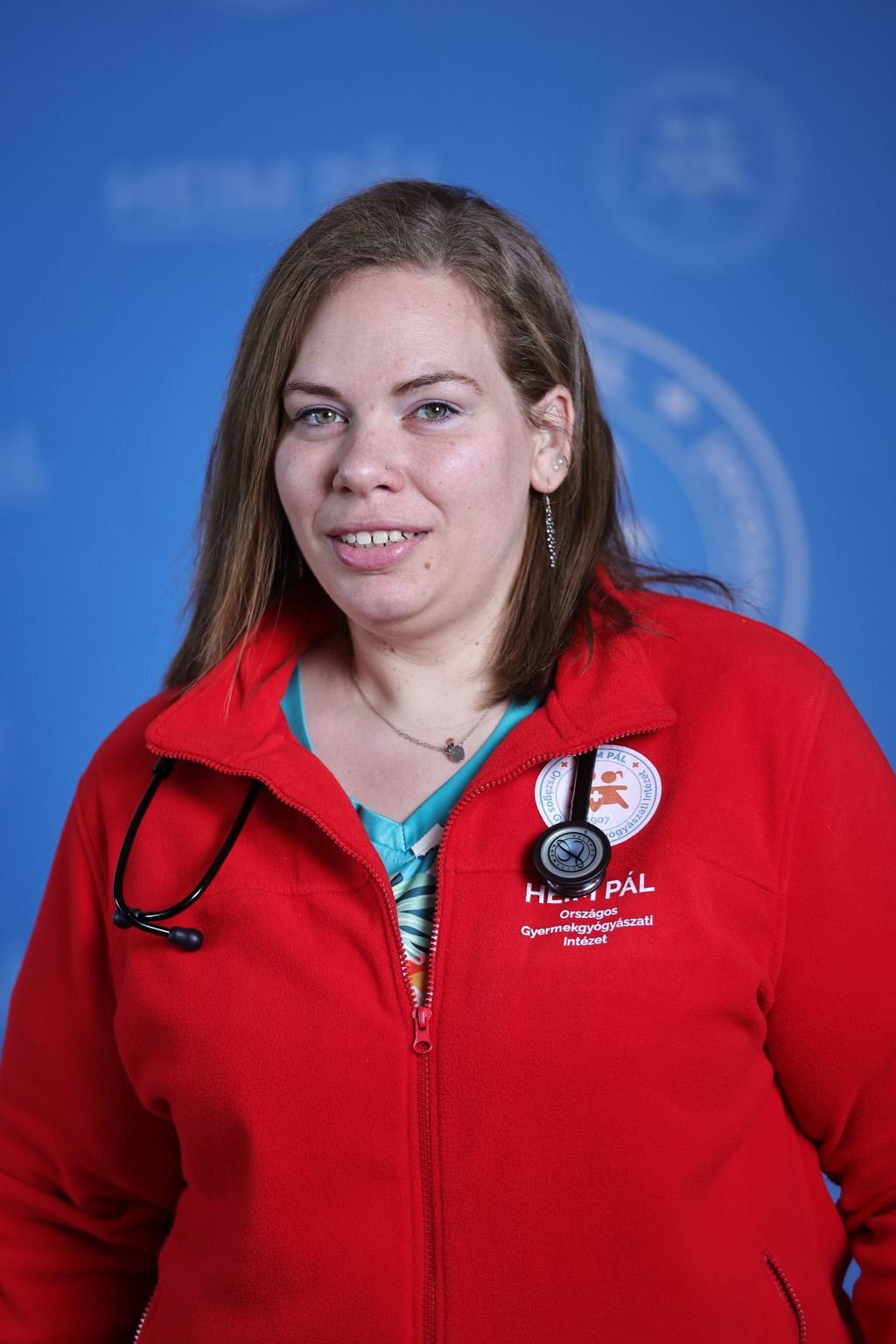 Barna hosszúhajú nő piros kardigánban