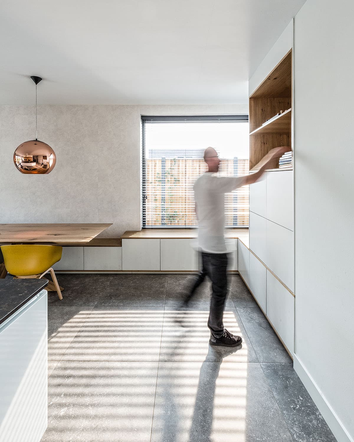 Moderne keuken met wit kookeiland, houten kastenwand en donkere vloer