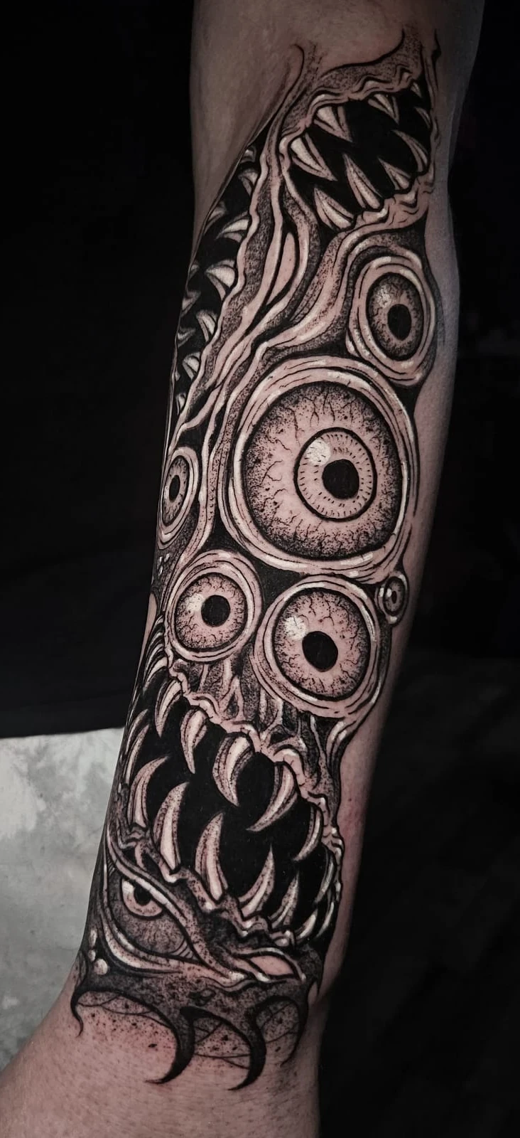 Eyes and fangs forearm tattoo by Alberto