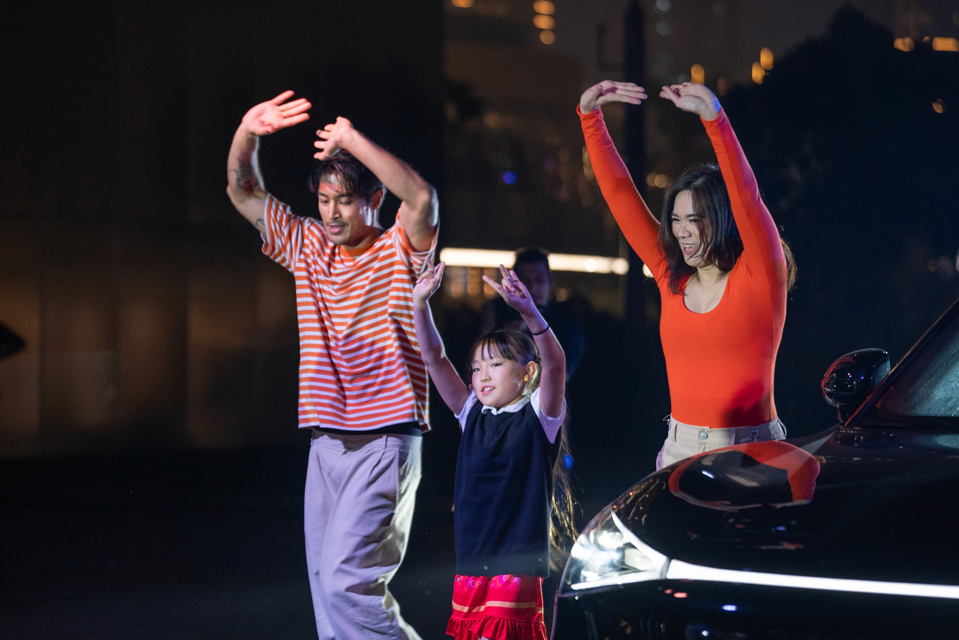 Family lifestyle performers dancing beside smart car during smart car reveal flashmob in Dubai, including adult performers and child performer