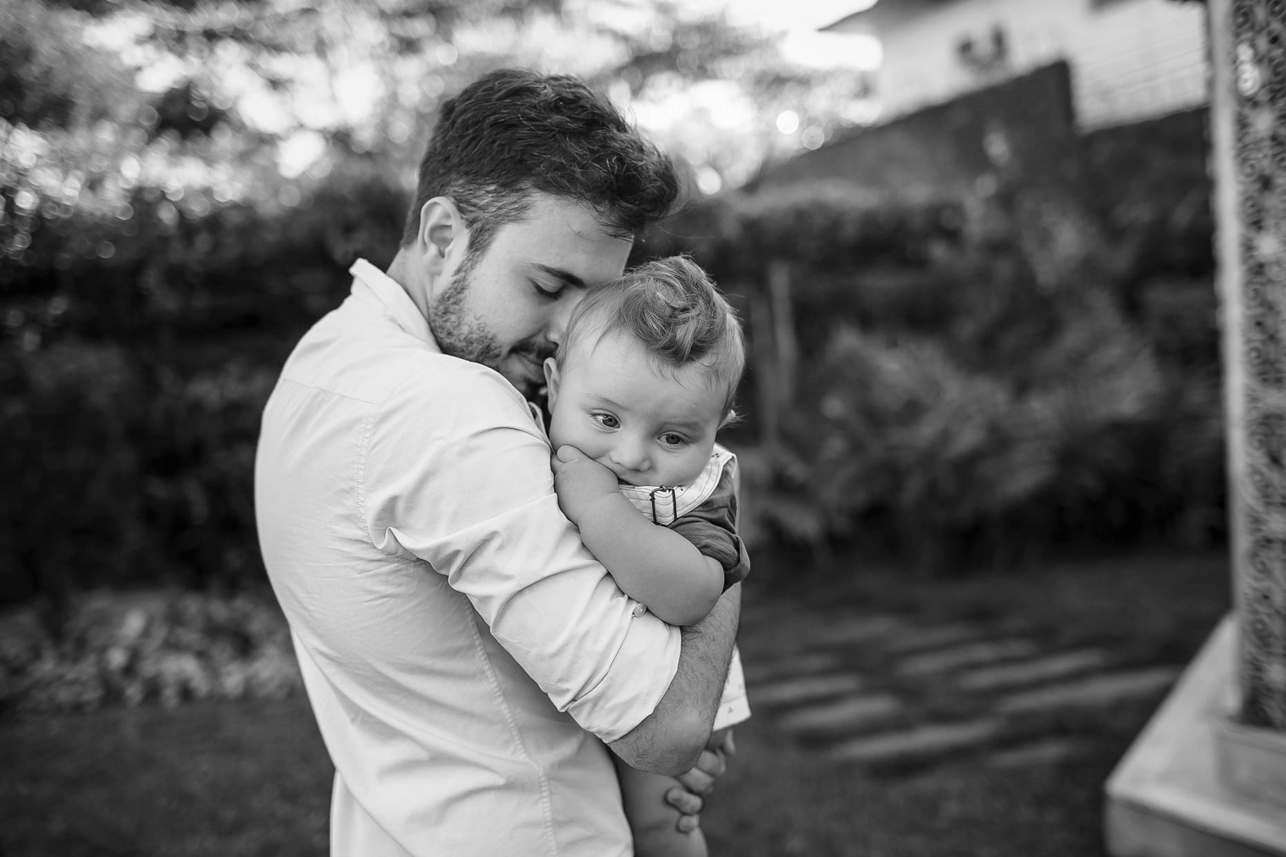 A young father hugging his infant.