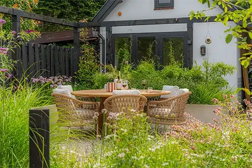 Outdoor garden furniture set from Bali COCO in a lush garden setting.