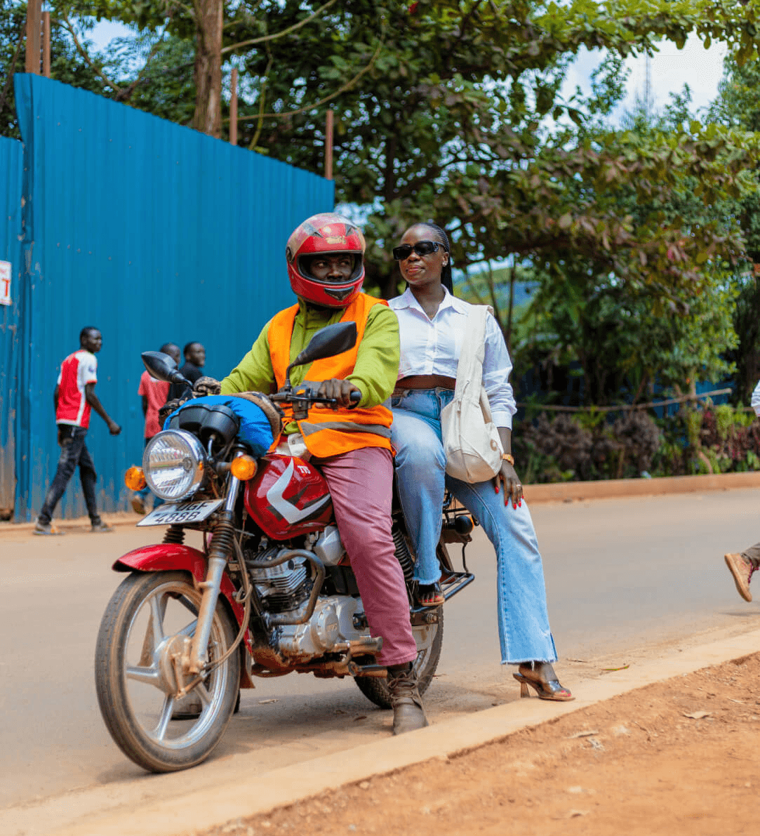 Mary Consolata Namagambe rides on the back of a motorbike in Uganda, Africa