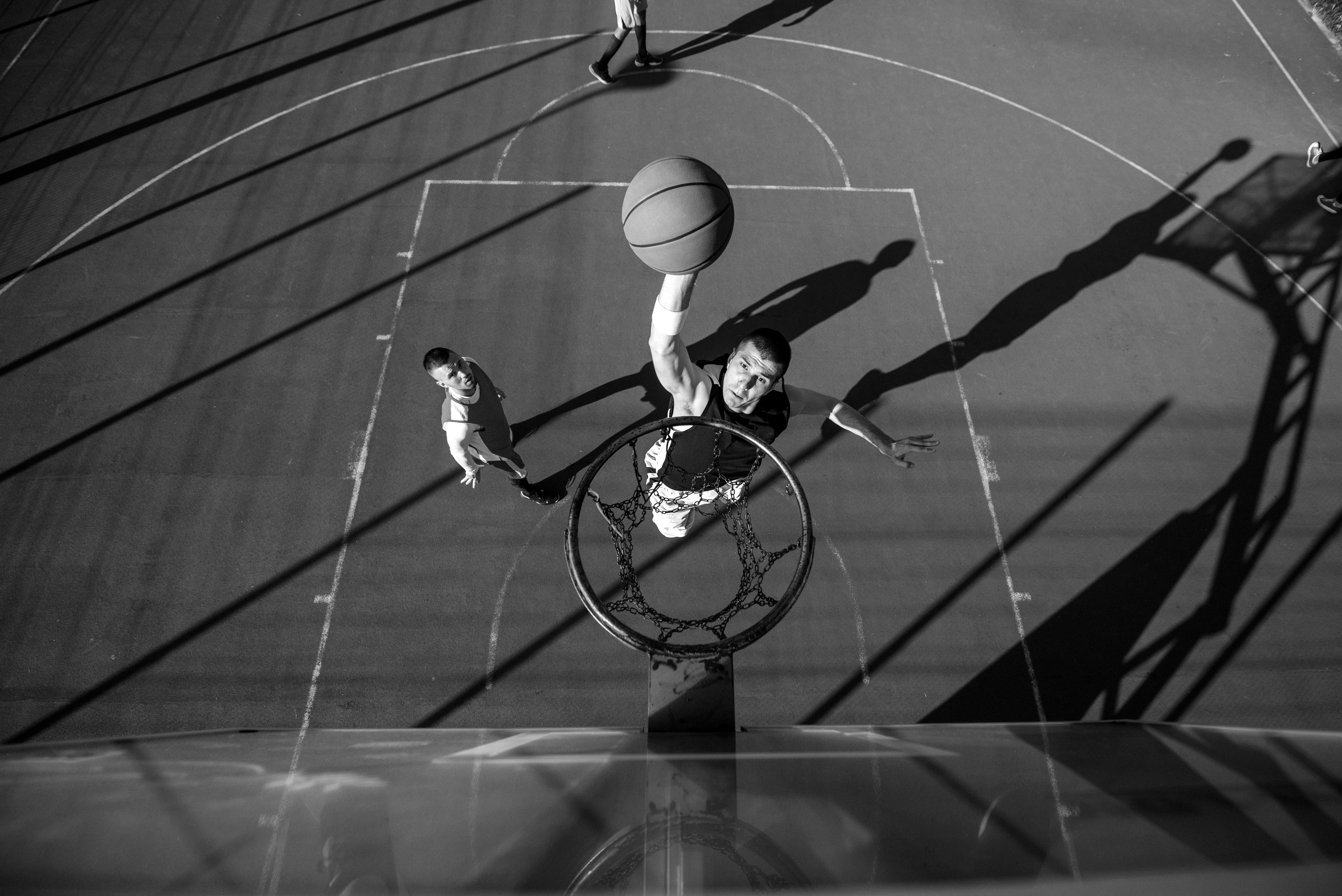 A woman in a striped shirt holds a credit card while using a laptop, bathed in warm sunlight in a cozy, modern setting.