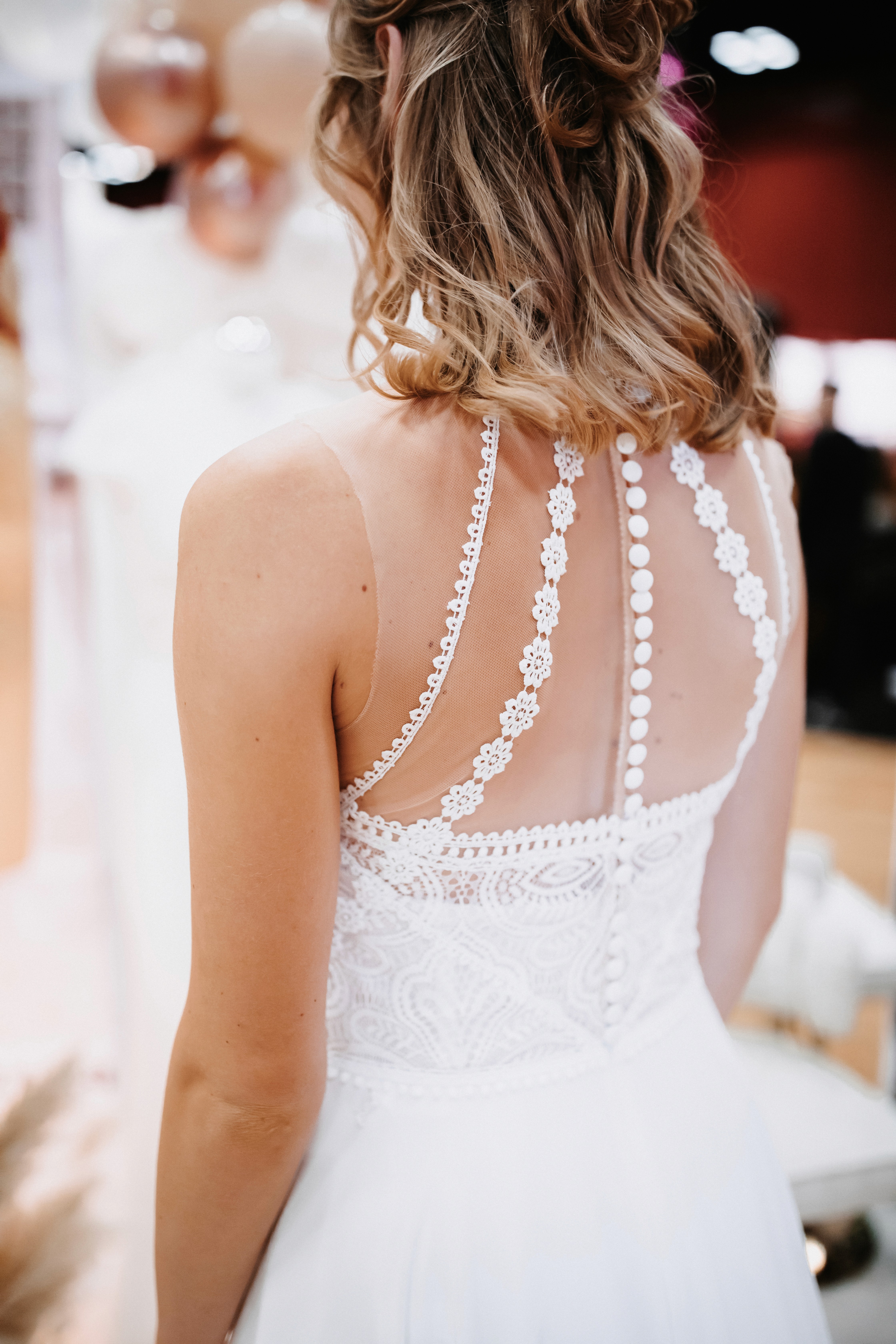 Eine Braut in einem verspielten Hochzeitskleid berät sich mit ihrer Stylistin.
