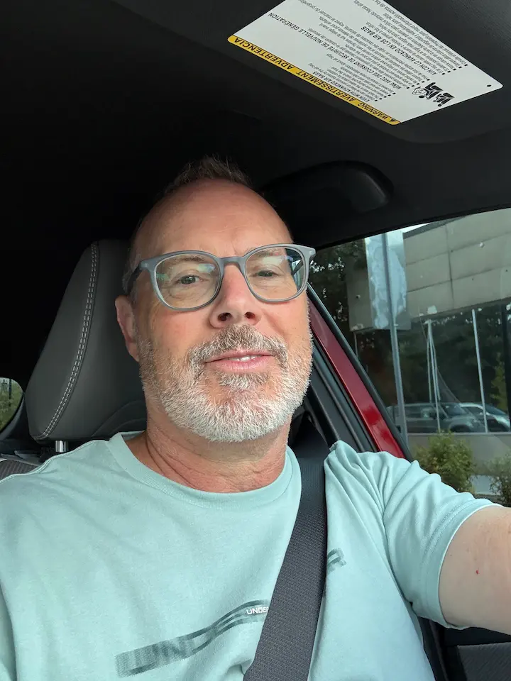 Selfie of Stu sitting in the driver’s seat of his car, looking at the camera.