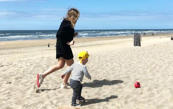 Babysitter Eveline with her babysitting child on the beach