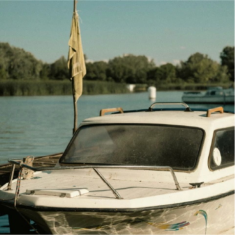a white boat is docked at a dock