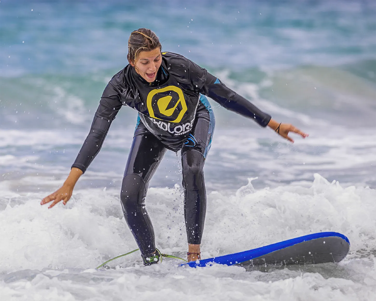 Beginner enjoying surf lessons in Tarifa with Explora Watersports – learning to ride waves in the shallow surf