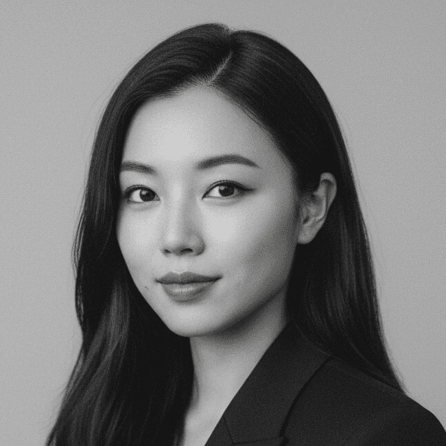 Portrait of a woman with long, smooth hair swept to the side, in a dark t-shirt, on a plain background.