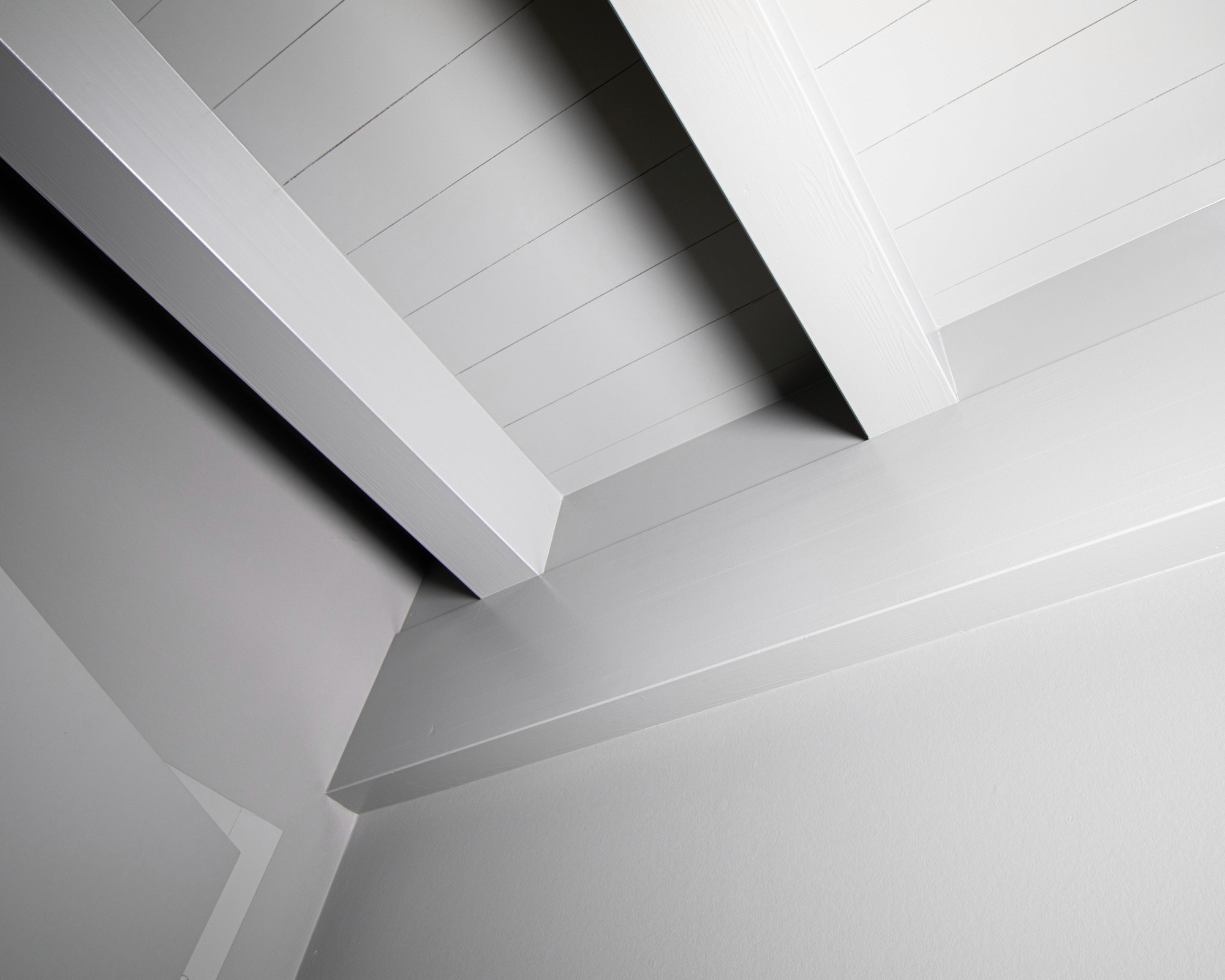 Photo abstraite d'un angle de plafond intérieur d'une chambre avec des poutres repeintes en blanc