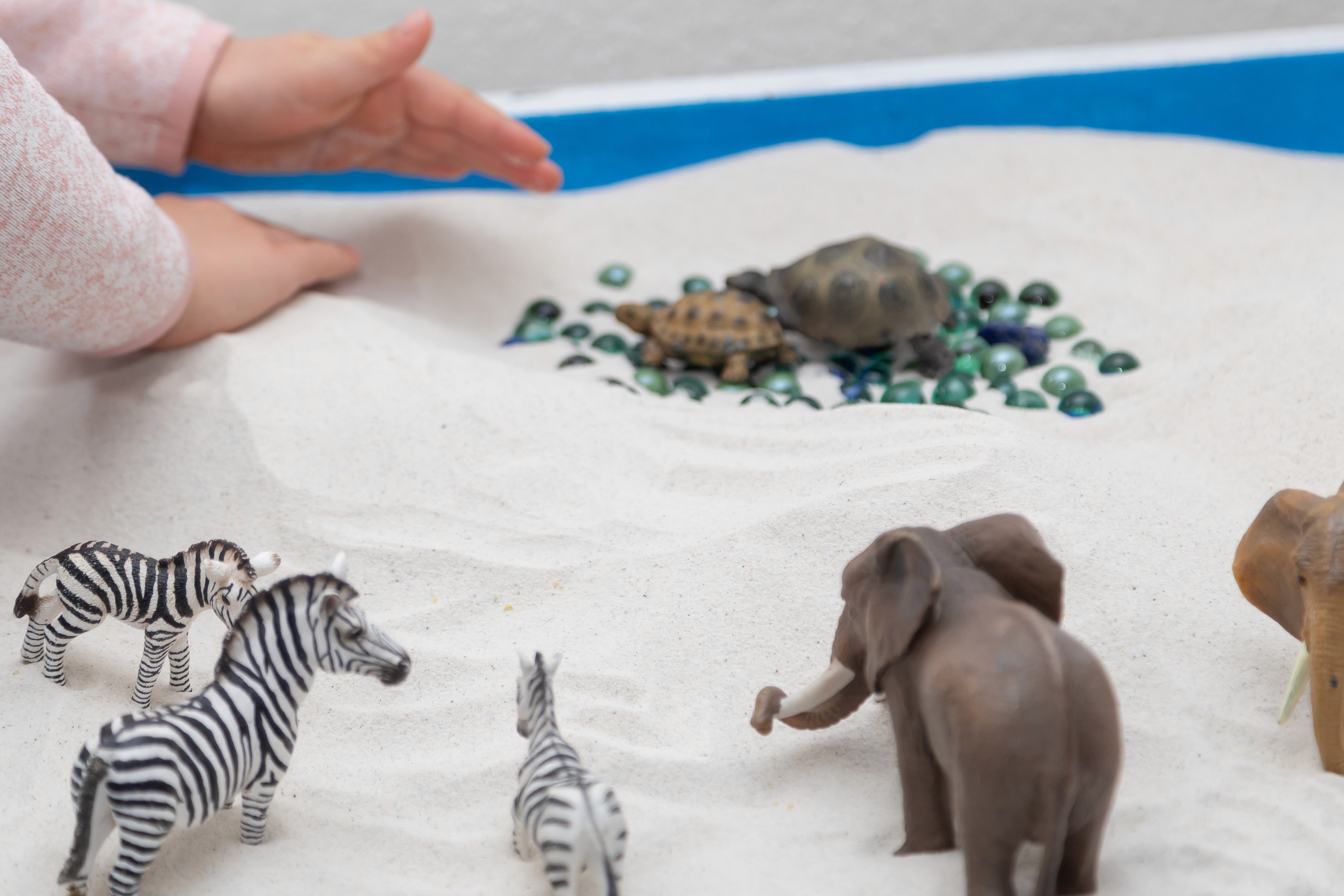 Bild der Praxis - Kind spielt mit Sand