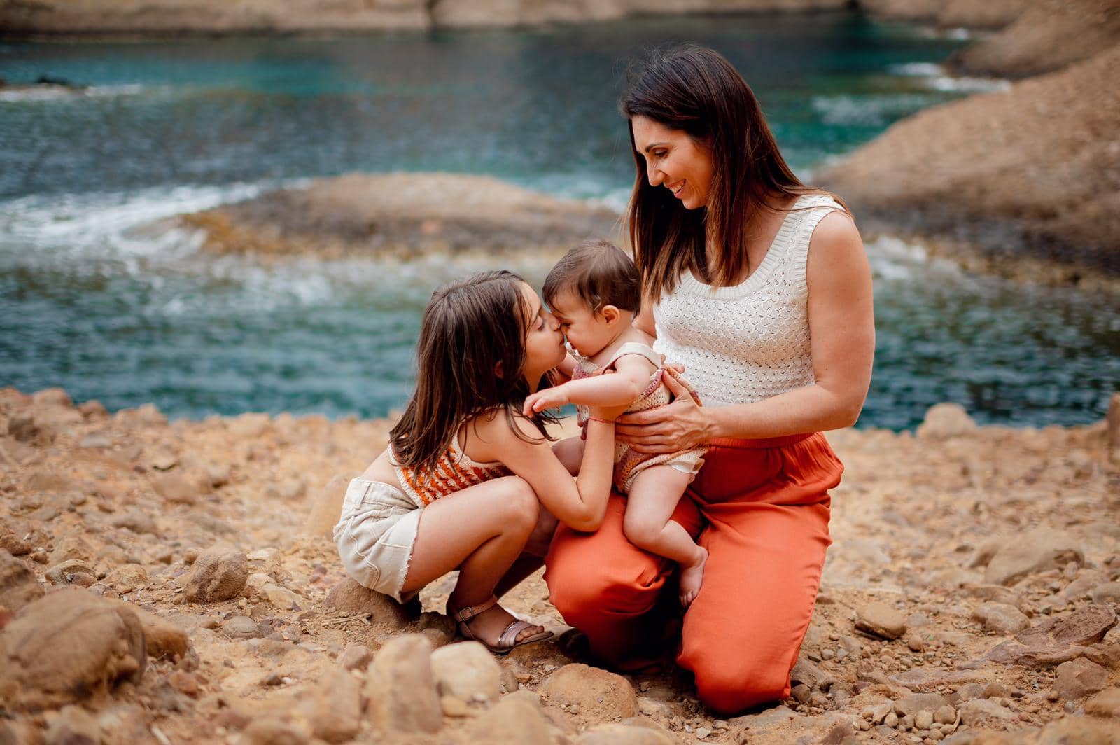 Caroline Rinaudo, coach sportive experte en maternité, partageant un moment de tendresse en extérieur avec ses deux filles.