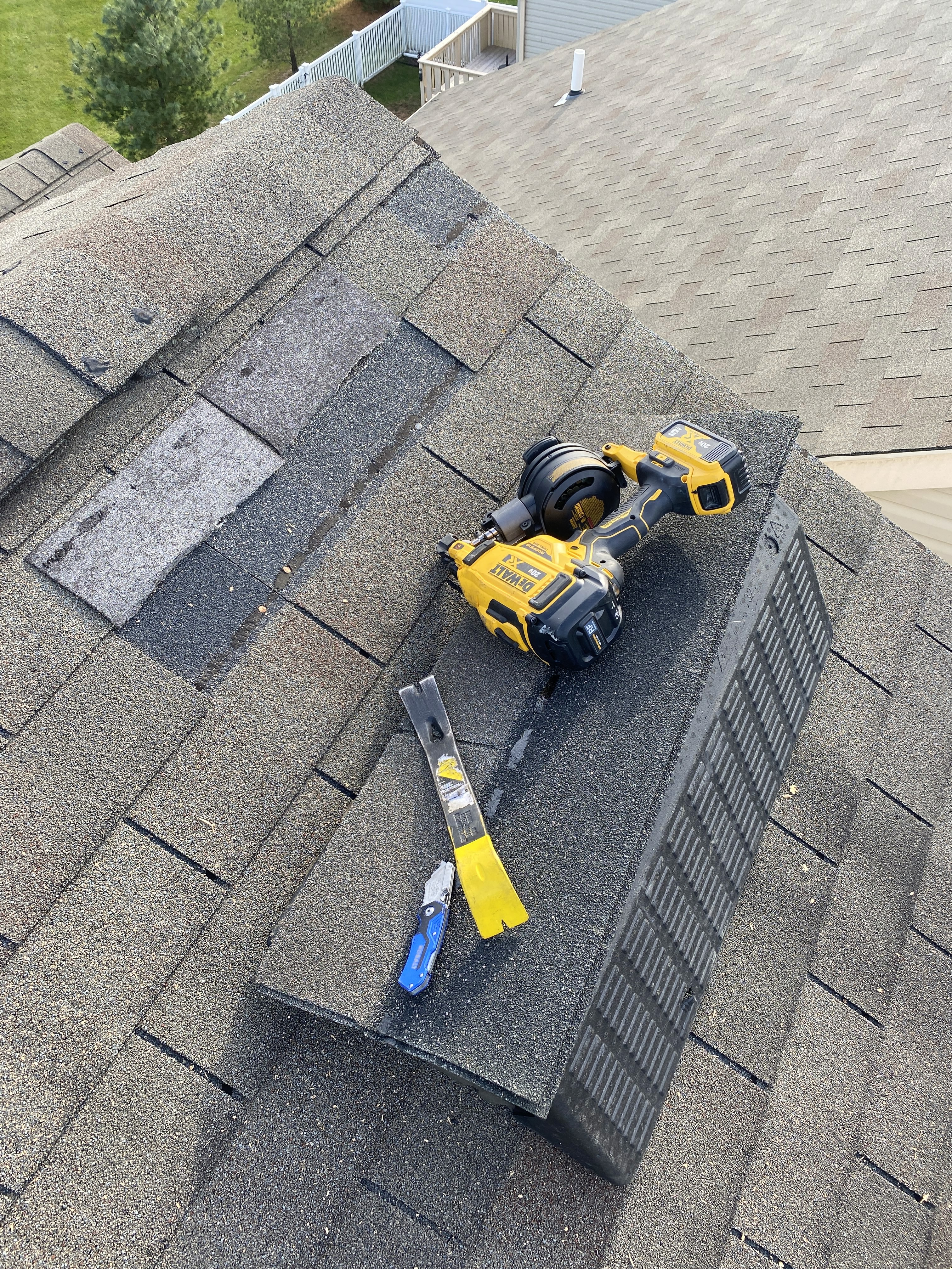 Using a roofing nail gun and shingle prybar to replace missing shingles from wind damage
