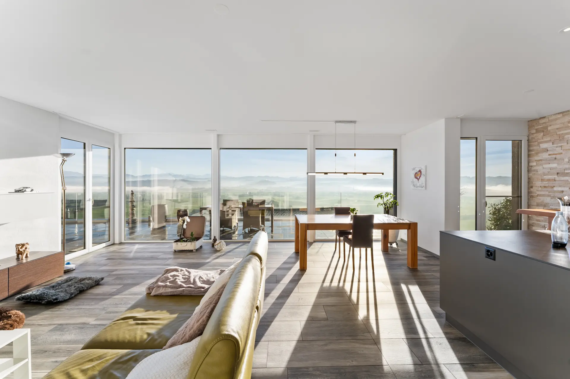 Stilvoll eingerichtetes Wohnzimmer mit grossen Fensterfronten und Aussicht über Egolzwil