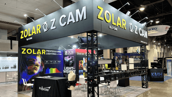 ZOLAR Z CAM NAB Show 20x30 operator counter and workflow booth with camera product displays, screen-led demo wall, branded overhead structure, and visitor viewing path
