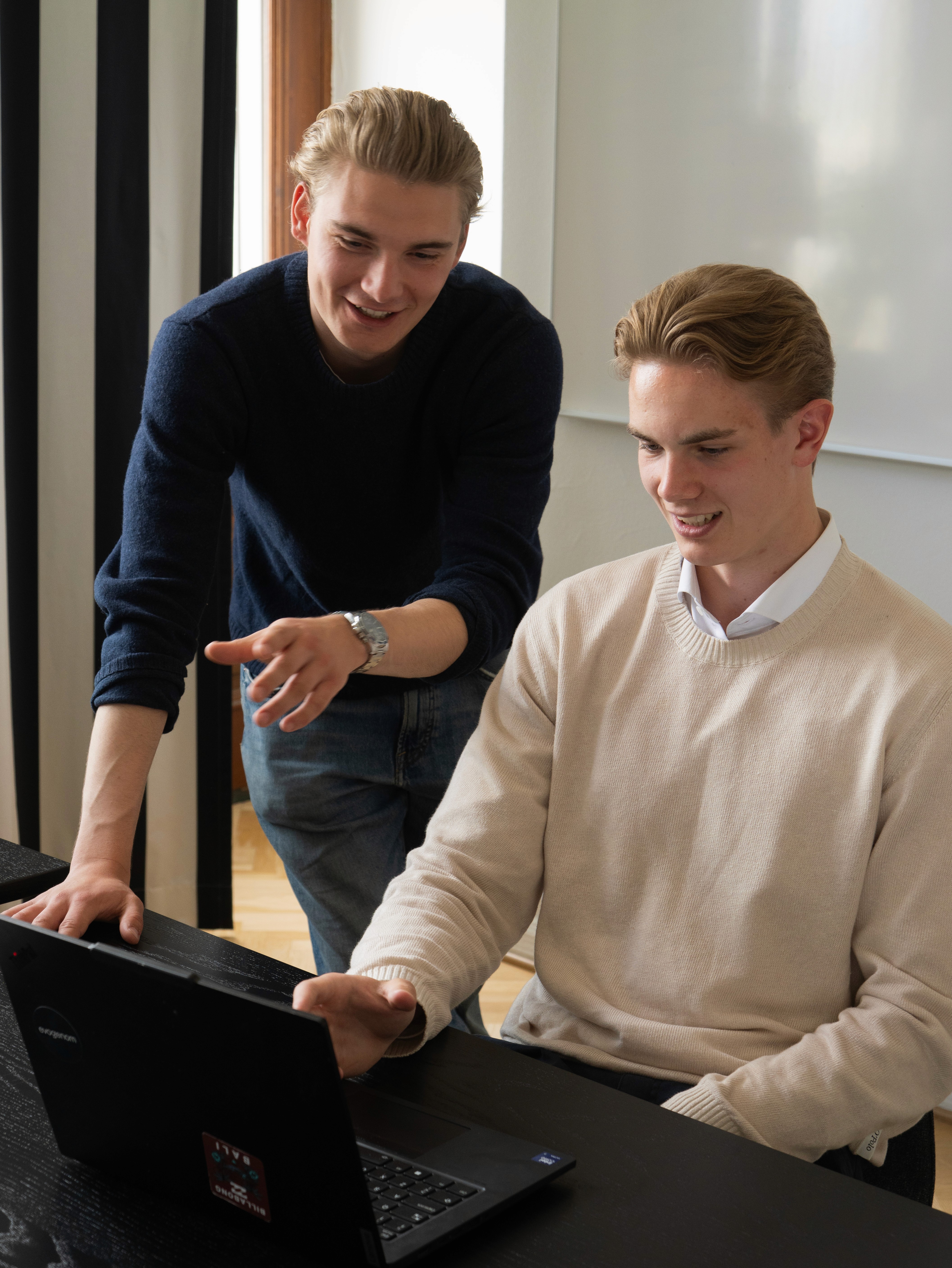 A man helping another man with his computer