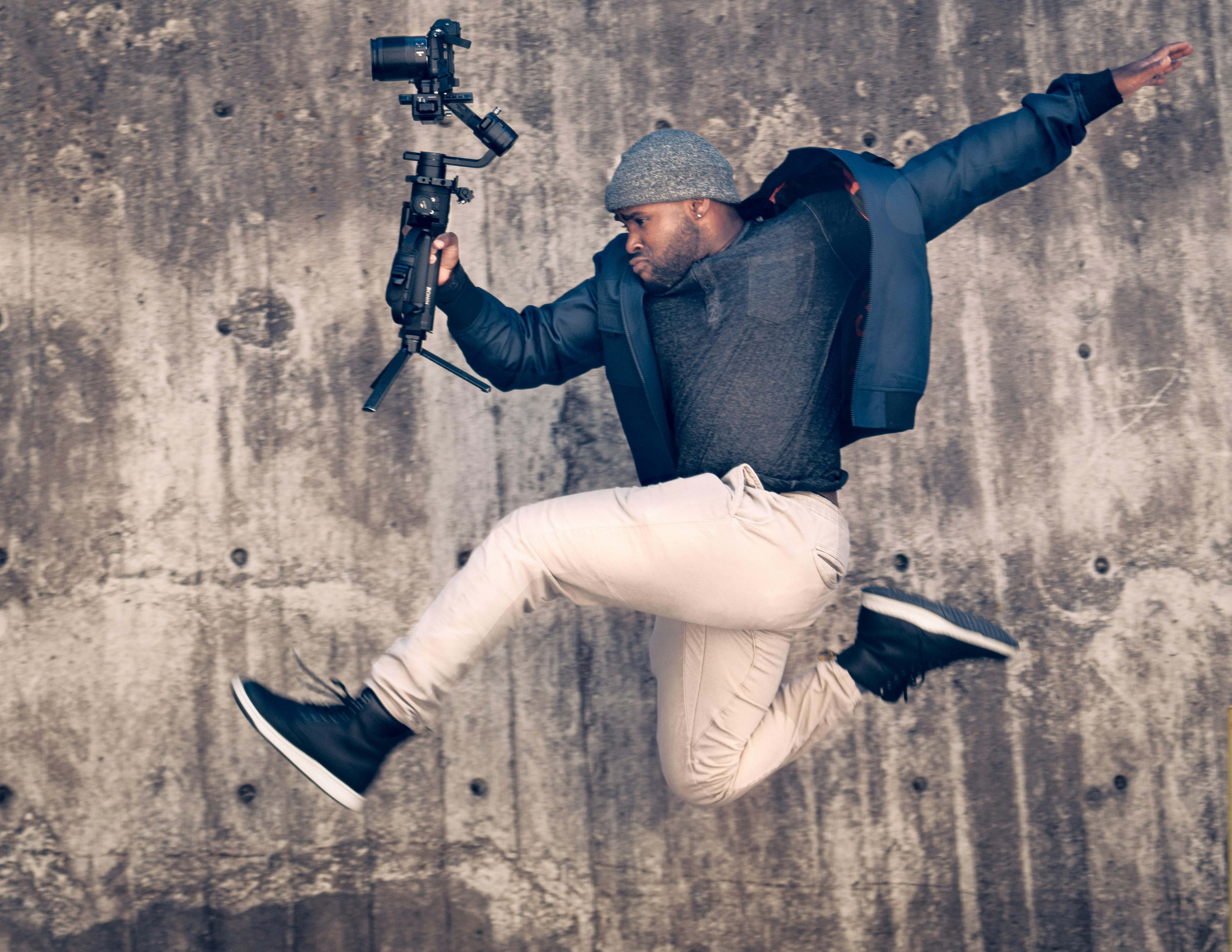 man jumping with camera - Content Creator Instagram