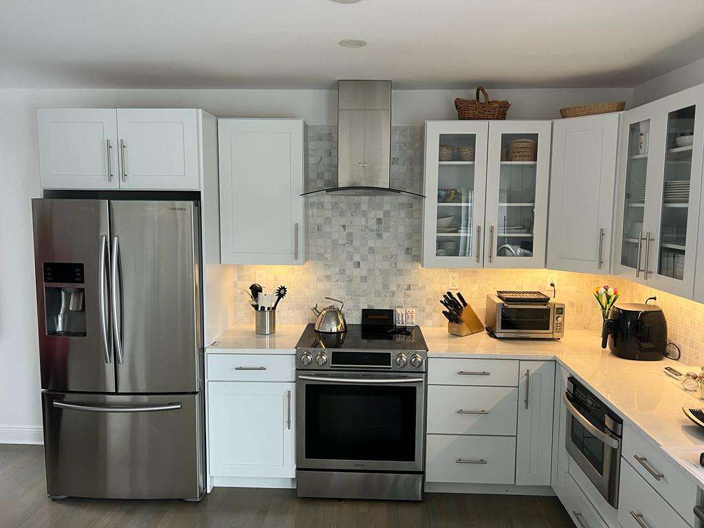 White outdate kitchen with tile backsplash before being fully remodeled