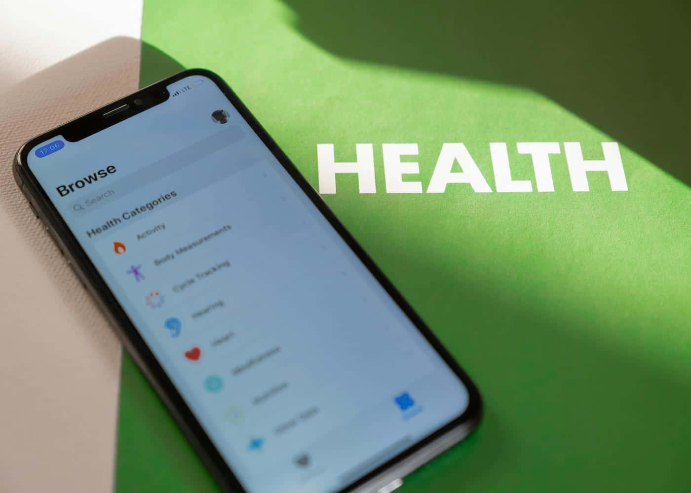 iPhone sreen showing health settings next to a green piece of paper that reads HEALTH