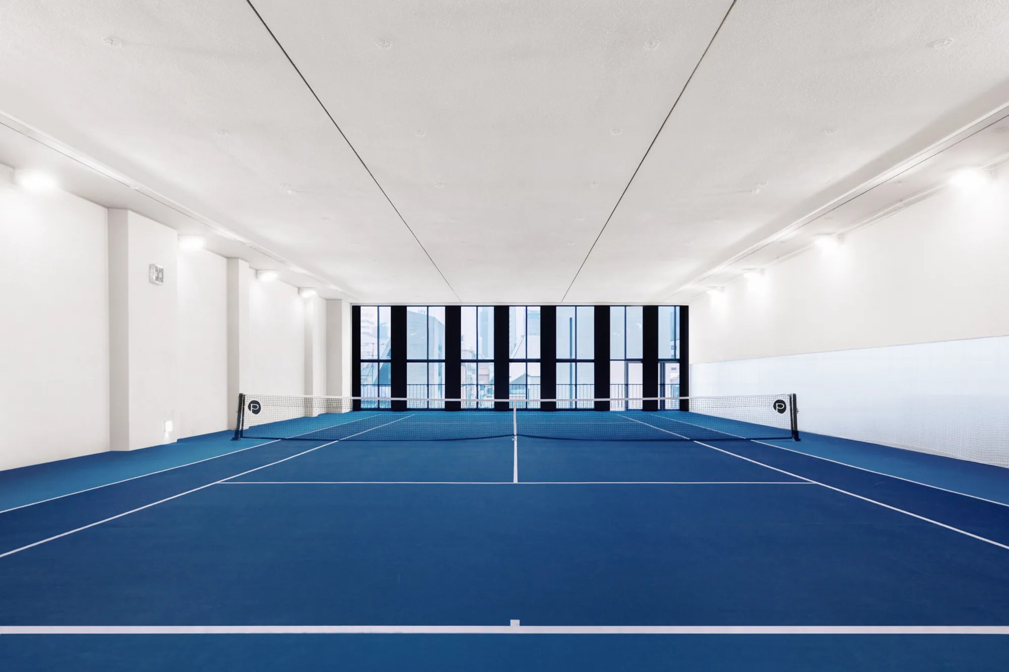 PLAYA indoor tennis court with a ball cart