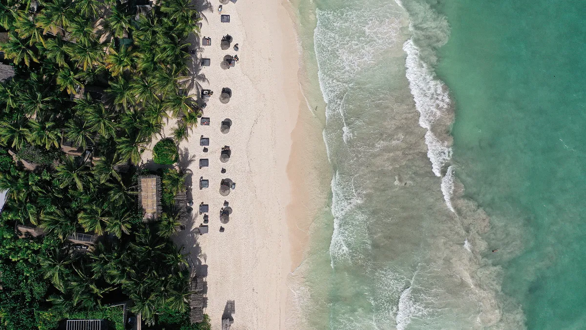 Guest relaxing on the beach, soaking up the sun and enjoying the ocean views at Nomade Holbox in Tulum Mexico
