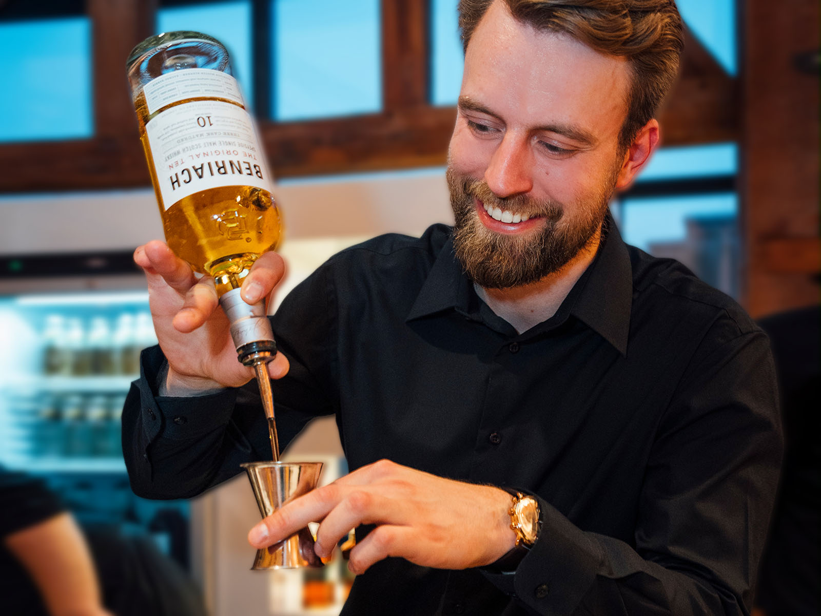 Barkeeper präsentiert eine Whisky-Flasche an der mobilen Bar